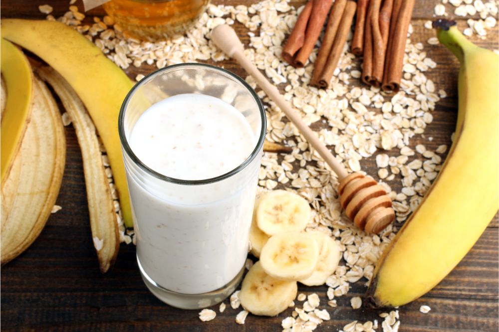 yogurt with banana and cereal on wooden brown background