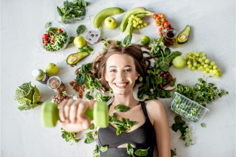 Beauty portrait of a sports woman surrounded by various healthy food lying on the floor.