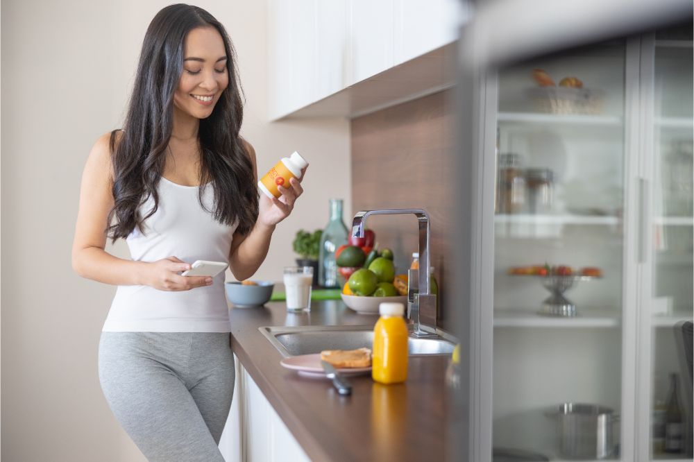 woman holding a vitamin bottle in the kitchen