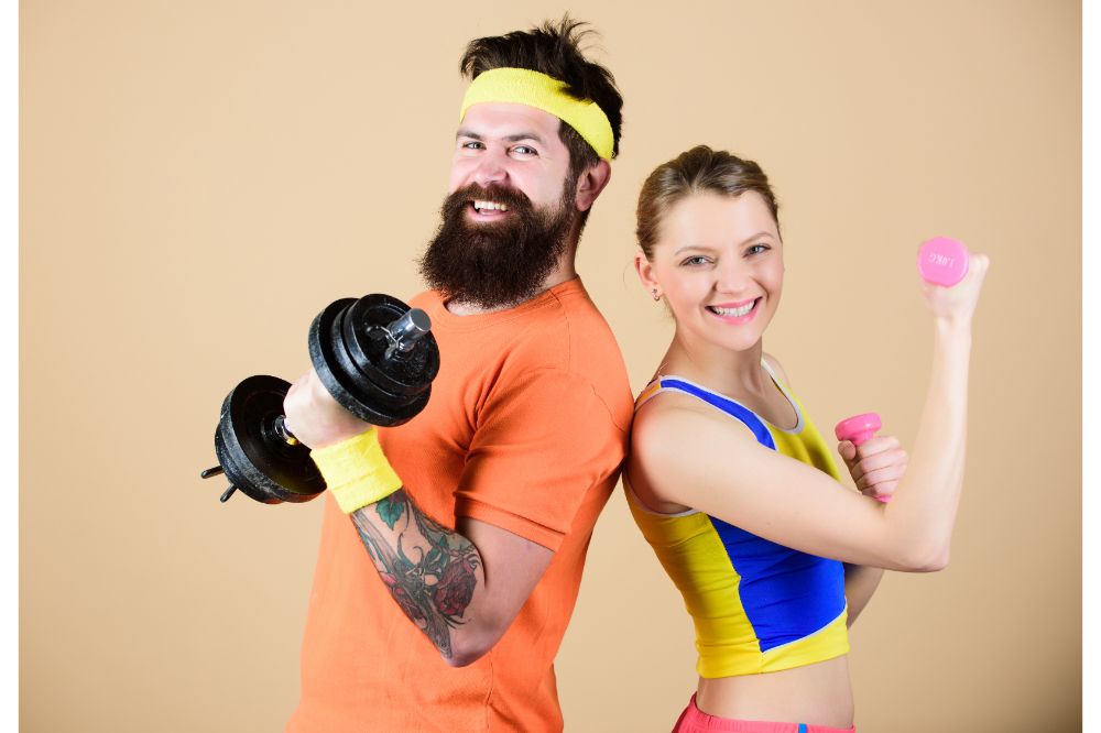 Man and woman exercising with dumbbells